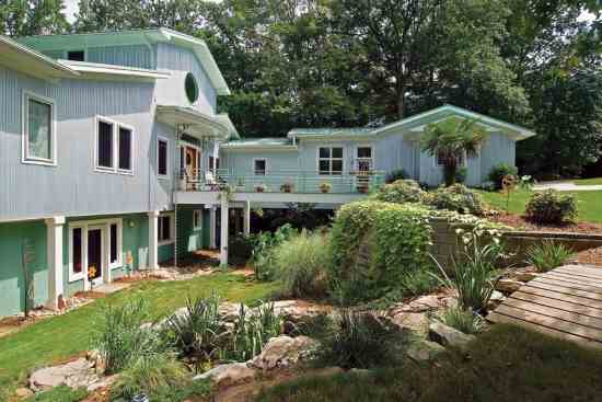 The site’s deep slope created drainage issues. By elevating the main home to driveway-level and incorporating a pond and a lovely water garden (with help from Jan Enright Creations), Jenny was able to save the original home.